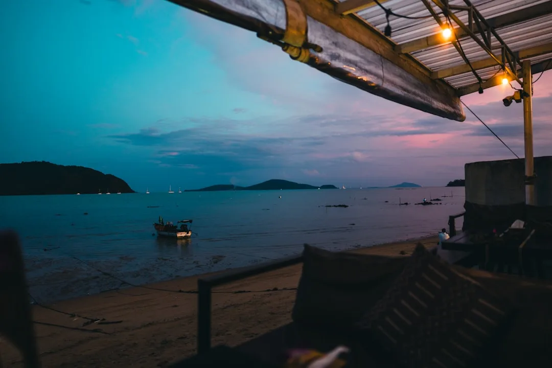 Sunset at Phuket beach club — golden hour over the Andaman Sea from an infinity pool