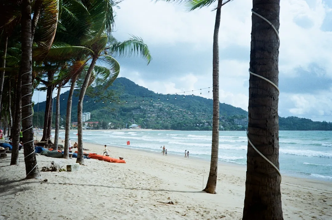Patong Beach Phuket at sunrise — 2.85 km of white sand with turquoise Andaman Sea and jungle hills behind