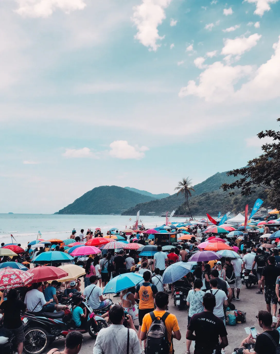 Crowds with colourful umbrellas gathering on a Phuket beach for Songkran water festival celebrations